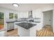 Modern kitchen showcasing white cabinets, dark countertops, stainless steel appliances, and hardwood floors at 11172 W Exposition Dr, Denver, CO 80226