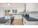 Bright kitchen featuring white cabinets, dark countertops, stainless steel appliances and hardwood floors at 11172 W Exposition Dr, Denver, CO 80226