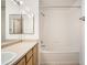 Clean bathroom featuring tub with shower and white tiling at 12711 Colorado Blvd # 607F, Thornton, CO 80241