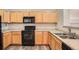 The kitchen showcases black appliances and abundance of light wood cabinets at 12711 Colorado Blvd # 607F, Thornton, CO 80241