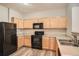 Efficient kitchen features sleek black appliances and ample wood cabinetry at 12711 Colorado Blvd # 607F, Thornton, CO 80241