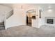 Cozy living room displaying open layout, fireplace, staircase, and kitchen view at 12711 Colorado Blvd # 607F, Thornton, CO 80241