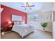 Comfortable bedroom with a brightly painted accent wall, ceiling fan, and a window with a view of the neighborhood at 2662 S Cathay Way # 112, Aurora, CO 80013