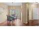Bright dining room featuring wood floors, a chandelier, and a glass table with seating for elegant meals at 2662 S Cathay Way # 112, Aurora, CO 80013