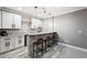 Stylish bar area with stone accents, granite countertop, white cabinets, and modern pendant lighting at 156 Chapel Hill Cir, Brighton, CO 80601