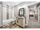 Bathroom with shower-tub combo, modern vanity, decorative mirror, and floral rugs at 156 Chapel Hill Cir, Brighton, CO 80601