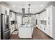 Elegant kitchen featuring white cabinets, a center island, and stainless steel appliances at 156 Chapel Hill Cir, Brighton, CO 80601