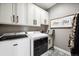 Laundry room with washer, dryer, patterned floors, storage cabinets, and sink at 156 Chapel Hill Cir, Brighton, CO 80601