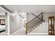 Staircase with carpeted steps, dark wood banister, and decorative iron spindles at 156 Chapel Hill Cir, Brighton, CO 80601