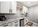 Attractive wet bar features white cabinets, granite countertops, wine rack, and stainless steel beverage cooler at 156 Chapel Hill Cir, Brighton, CO 80601