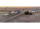 Expansive aerial view of the property featuring several buildings, sheds, and a gravel driveway in a rural landscape at 35055 E Mississippi Ave, Watkins, CO 80137