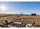 Inviting backyard featuring a cozy fire pit area with comfortable seating and views of the open countryside at 35055 E Mississippi Ave, Watkins, CO 80137