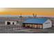 Wide shot of a barn with white siding and blue roofing that includes fencing and horse corrals at 35055 E Mississippi Ave, Watkins, CO 80137