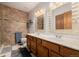 Bathroom featuring double sinks, stone countertops, decorative mirror and tiled shower, offering a luxurious experience at 35055 E Mississippi Ave, Watkins, CO 80137