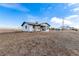 Quaint single-story home with a simple exterior, surrounded by an expansive, natural landscape at 35055 E Mississippi Ave, Watkins, CO 80137