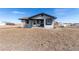 Exterior of a house with muted grey siding, a small front porch, and additional outbuildings on the property at 35055 E Mississippi Ave, Watkins, CO 80137