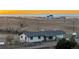 Single-story home with dark roof and white siding and partially fenced yard at 35055 E Mississippi Ave, Watkins, CO 80137