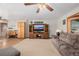 Cozy living room featuring comfortable seating, a wooden entertainment center, and natural light at 35055 E Mississippi Ave, Watkins, CO 80137