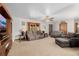 Spacious living room with a ceiling fan, a wooden entertainment center, and neutral walls and carpet at 35055 E Mississippi Ave, Watkins, CO 80137