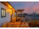 Charming covered porch with decorative pergola and view of the surrounding rural landscape at sunset at 35055 E Mississippi Ave, Watkins, CO 80137