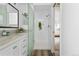 Bathroom featuring a double vanity, a glass shower door, and wood look tile floor at 1250 S Josephine St, Denver, CO 80210