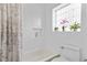 Bathroom featuring a shower/tub combo with tiled walls, and decorative glass block window at 1250 S Josephine St, Denver, CO 80210