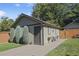 A detached garage with a small patio area featuring chairs and a walkway at 1250 S Josephine St, Denver, CO 80210