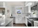 Kitchen boasts white cabinets, gray backsplash, stainless steel appliances and granite counters at 1250 S Josephine St, Denver, CO 80210