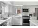 Well-lit kitchen with white cabinets, stainless steel appliances and stone tile backsplash at 1250 S Josephine St, Denver, CO 80210