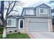 Charming two-story home featuring a gray exterior with brick accents and an attached two-car garage at 9724 Cove Creek Dr, Highlands Ranch, CO 80129
