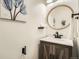 Charming powder room showcasing a wood vanity, round mirror, and stylish wall decor at 5150 Buckingham Rd, Boulder, CO 80301