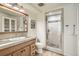 Bathroom features a wood vanity, tiled countertop, large mirror, and walk-in glass shower at 5150 Buckingham Rd, Boulder, CO 80301
