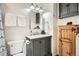 Stylish bathroom featuring a gray vanity, modern lighting, and a wooden storage cabinet at 5150 Buckingham Rd, Boulder, CO 80301