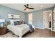 Light-filled bedroom featuring wood floors, a ceiling fan, and soothing blue walls at 5150 Buckingham Rd, Boulder, CO 80301