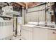 Basement laundry area with washer, dryer, furnace and hot water heater, and concrete walls at 5150 Buckingham Rd, Boulder, CO 80301
