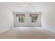 Spacious bedroom with neutral carpet, two windows, and a ceiling fan offering ample natural light at 14139 W Warren Dr, Lakewood, CO 80228