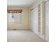 Neutral bedroom with bright lighting, closet doors, and a window at 14139 W Warren Dr, Lakewood, CO 80228