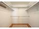 Walk-in closet features laminate wood flooring, white shelves, and chrome hanging rods for optimal organization at 14139 W Warren Dr, Lakewood, CO 80228