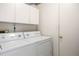 Laundry room with white washer, dryer, and storage cabinets at 14139 W Warren Dr, Lakewood, CO 80228