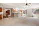 Open-concept living room and kitchen area with neutral carpet and lots of natural light at 14139 W Warren Dr, Lakewood, CO 80228