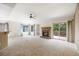 Spacious living room with a fireplace, a ceiling fan, and sliding glass doors to a deck at 14139 W Warren Dr, Lakewood, CO 80228