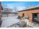 Cozy backyard patio area features a built-in grill, snow covered patio, and brick privacy wall at 1131 S York St, Denver, CO 80210