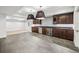 Basement bar features dark wood cabinets with a beverage refrigerator and unique pendant lighting at 1131 S York St, Denver, CO 80210