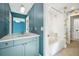 Bright bathroom featuring double sinks, shower over tub, and blue walls at 1131 S York St, Denver, CO 80210