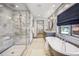 Bright bathroom features a glass shower with marble tile and a soaking tub next to a window at 1131 S York St, Denver, CO 80210