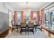 Elegant dining room featuring a grand chandelier, gray wainscoting, and bright windows with coral drapes at 1131 S York St, Denver, CO 80210