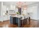 The modern kitchen features a large island with seating, white cabinetry and stainless appliances at 1131 S York St, Denver, CO 80210