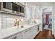 Bright kitchen features white cabinets, marble countertops, stainless steel appliances, and tile backsplash at 1131 S York St, Denver, CO 80210
