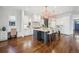 Open kitchen with gray island, seating, stainless steel appliances, marble countertops, and hardwood floors at 1131 S York St, Denver, CO 80210
