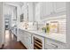 Bright kitchen features white cabinets, marble countertops, stainless steel appliances, tile backsplash, and a wine fridge at 1131 S York St, Denver, CO 80210